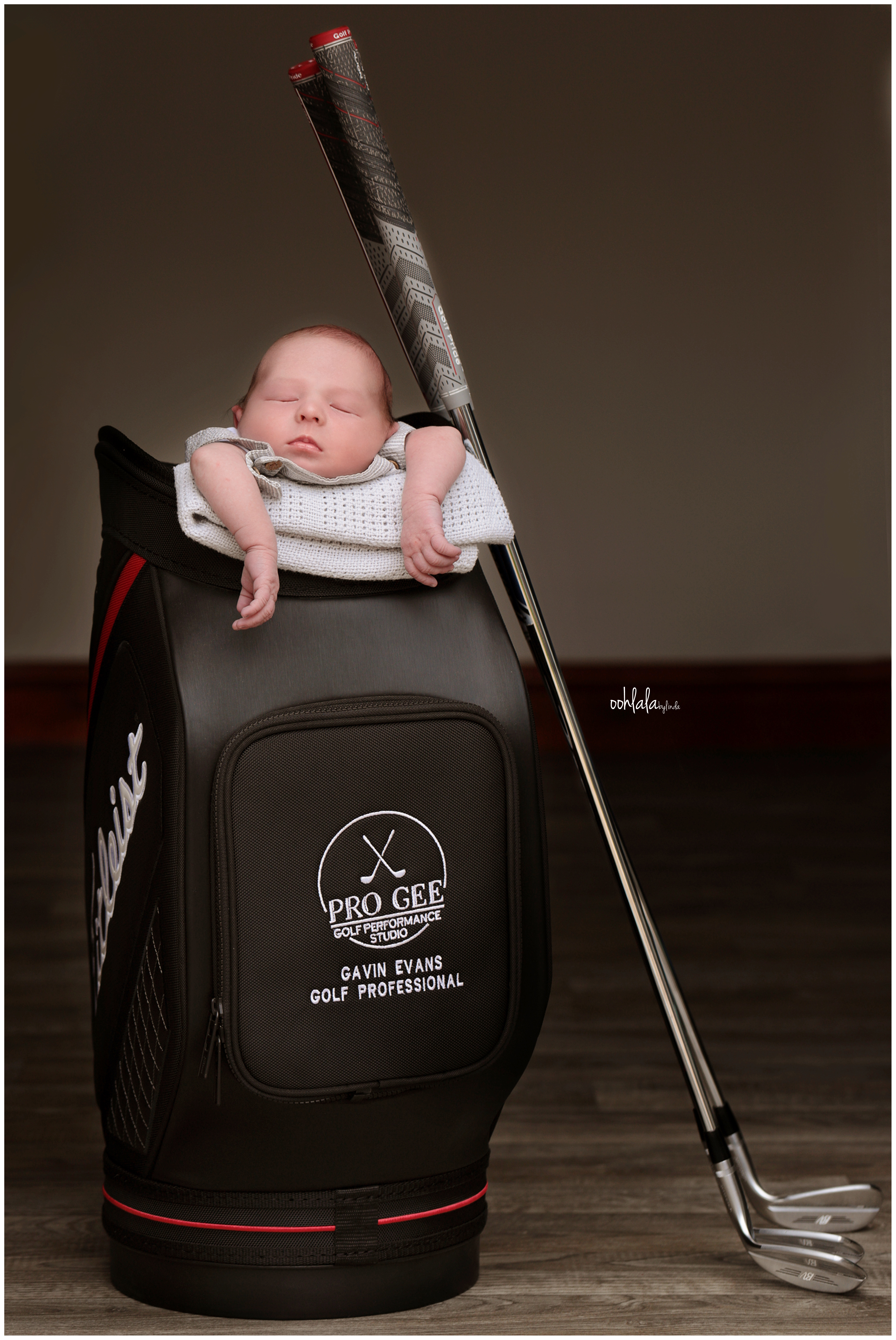 baby in a golf bag with clubs