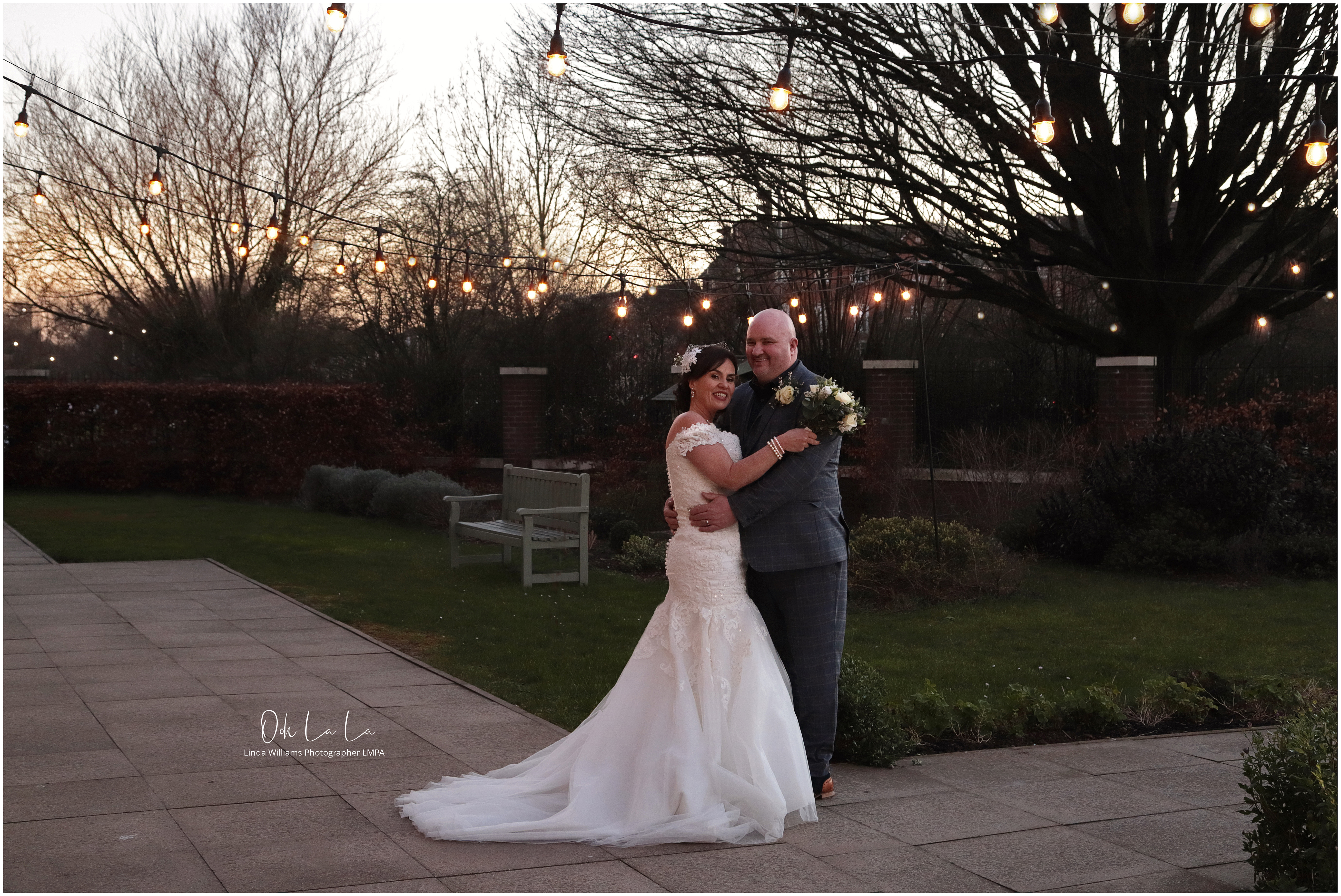 bride and groom under fairy lights