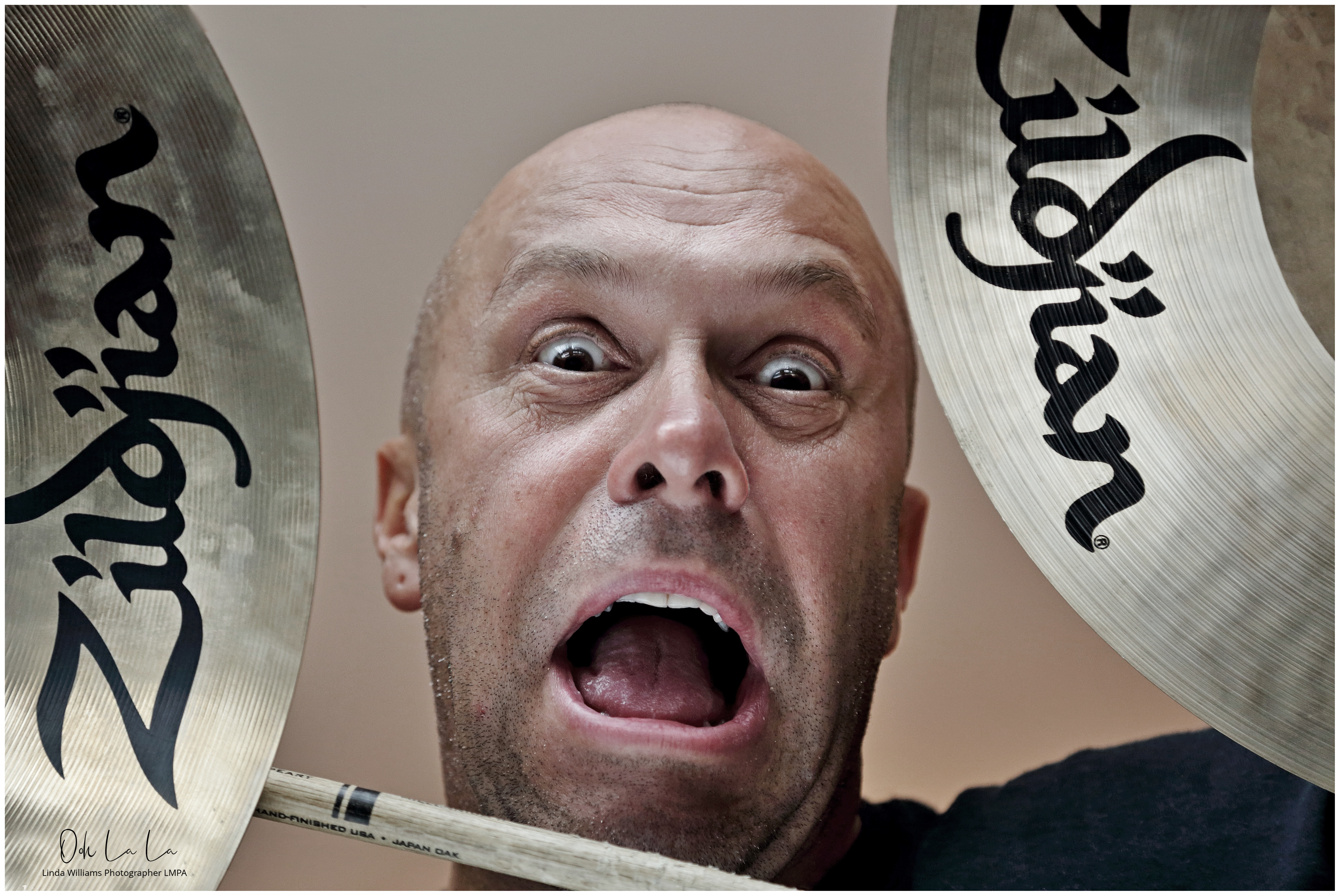 drummer pulling crazy face through drum kit