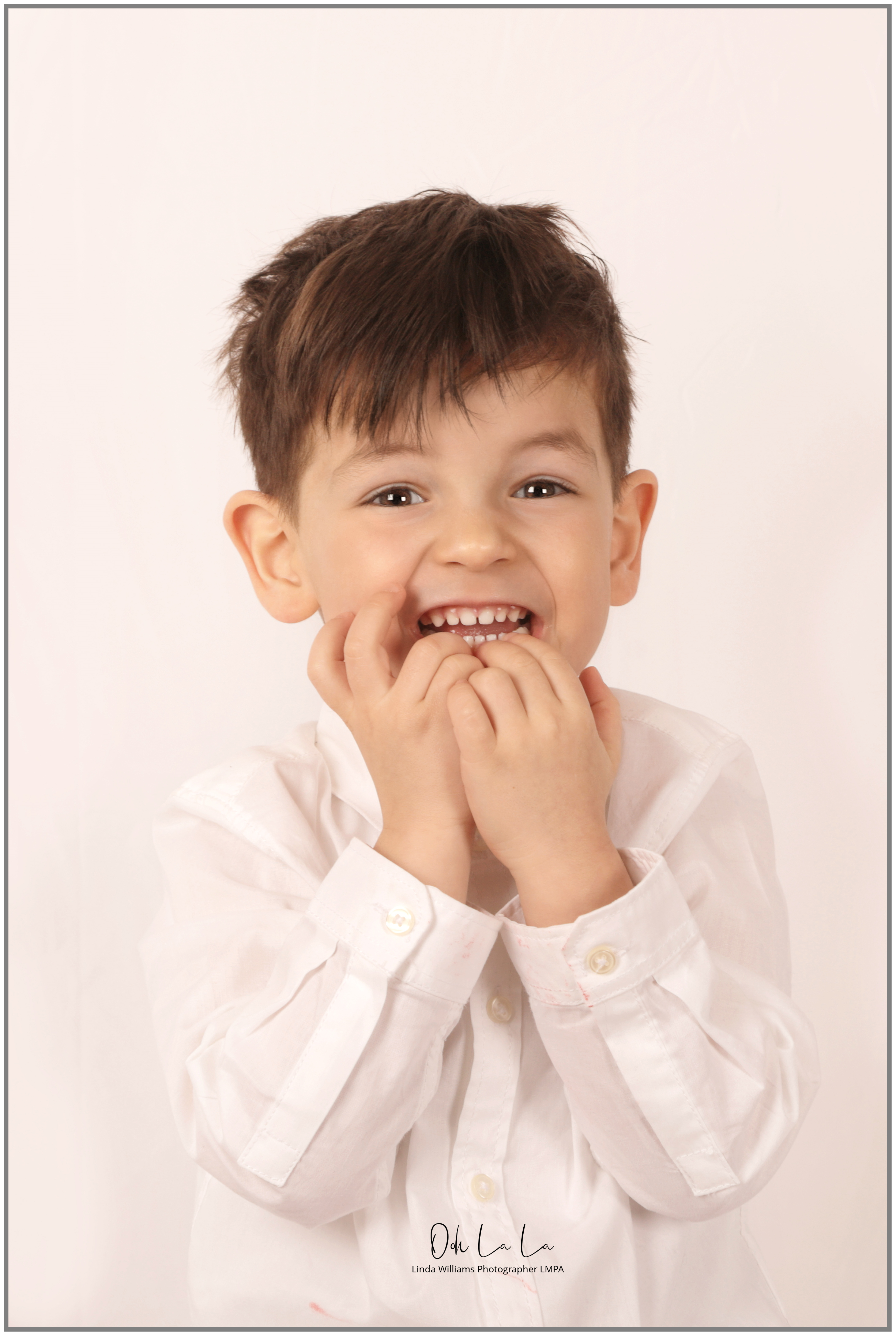 laughing little boy in white shirt with white background
