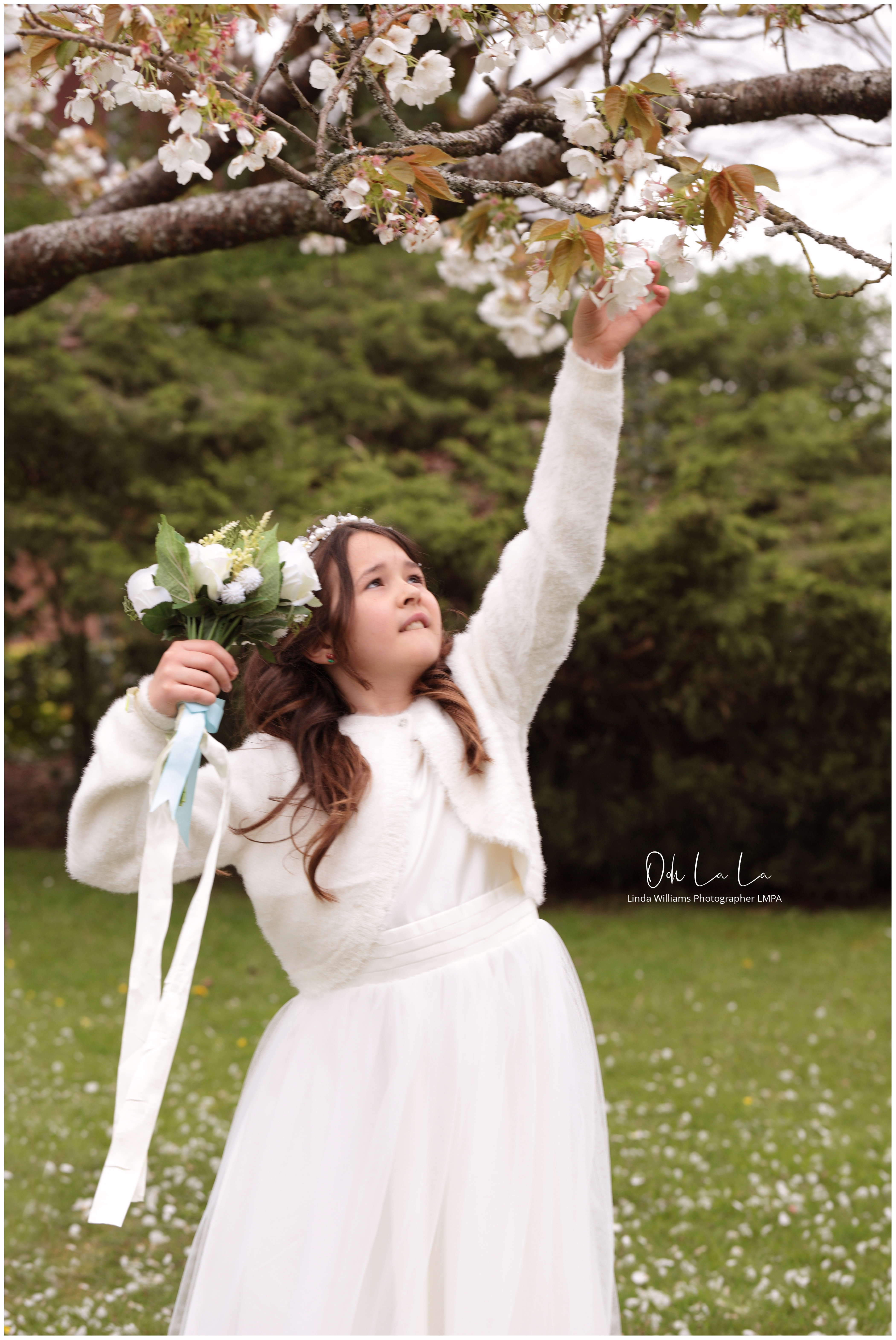 little bridesmaid picking blossom from a tree