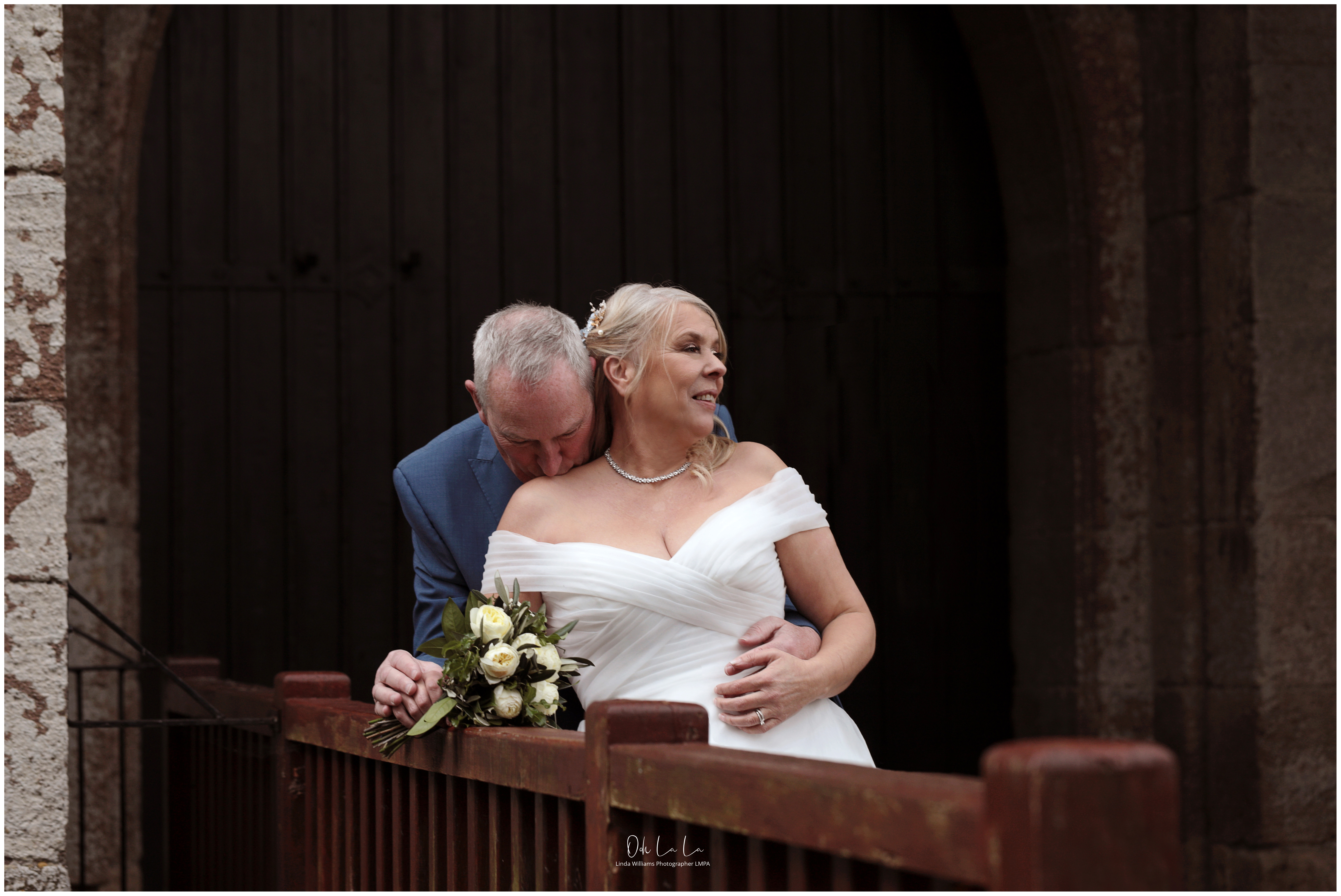 groom tenderly kissing brides shoulder