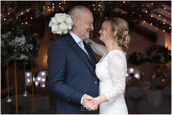 bride and groom surrounded by lights looking at each other