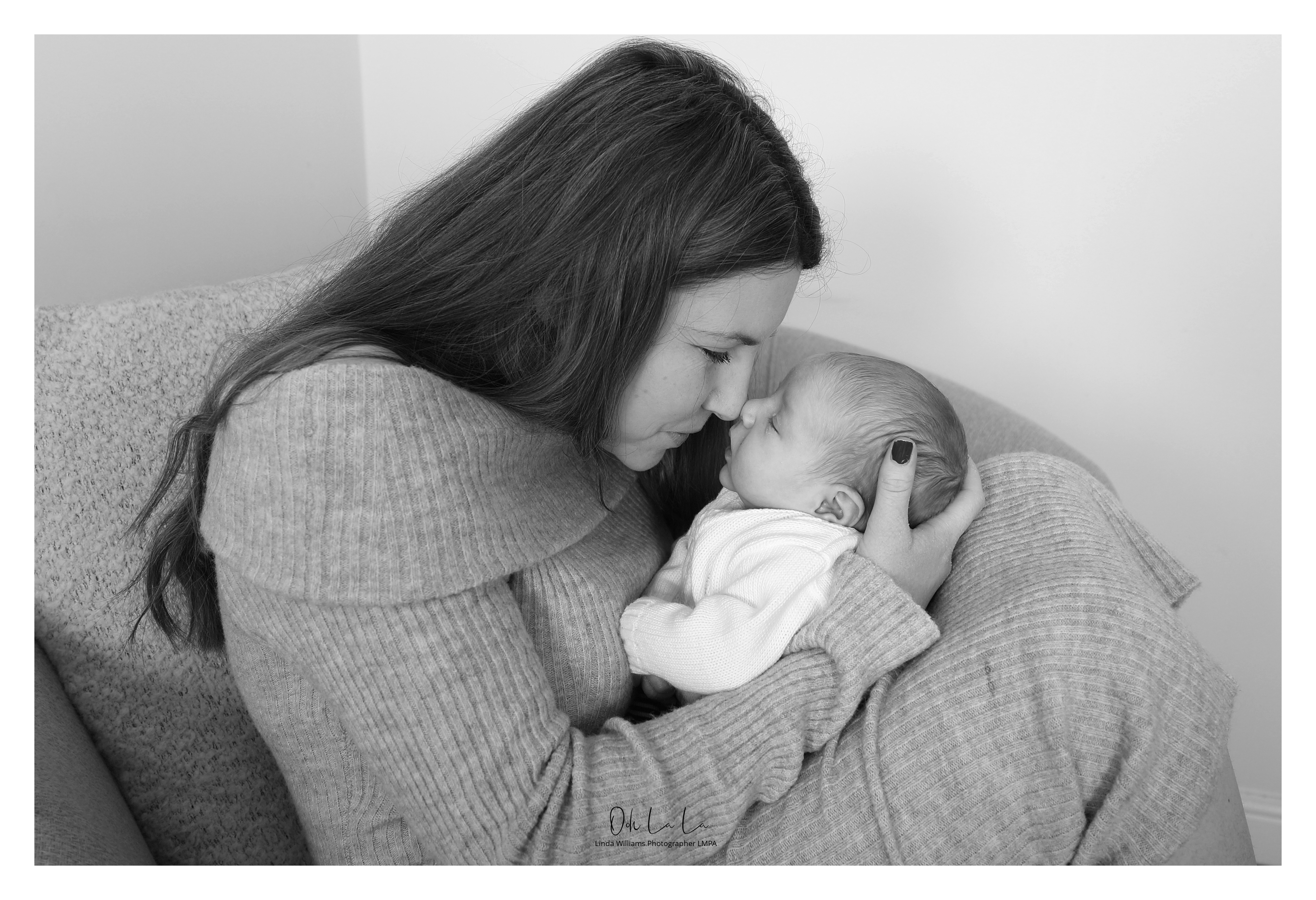 black and white of young mum touching noses with her new born baby boy